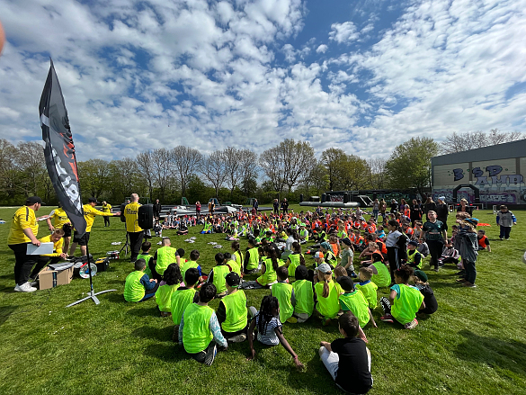 Viele Kinder in sportlicher Kleidung auf einer großen Wiese